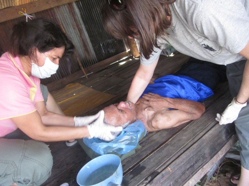 Our staff caring for a poor, handicapped homeless man from Burma.